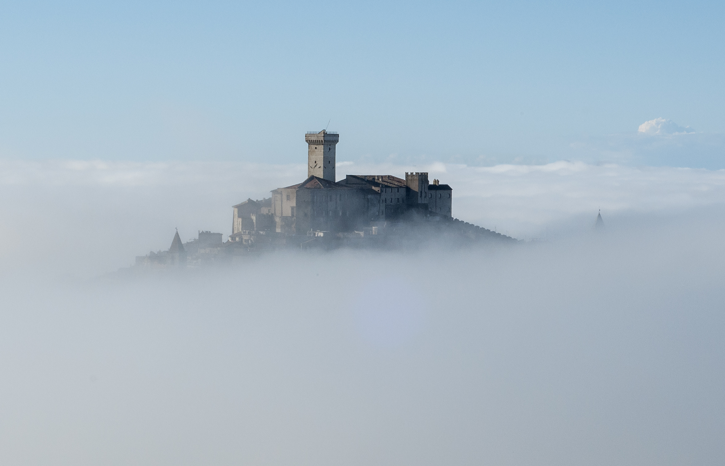 Il Castello Savelli che emerge dal mare di nebbia all'alba, sopra Palombara Sabina